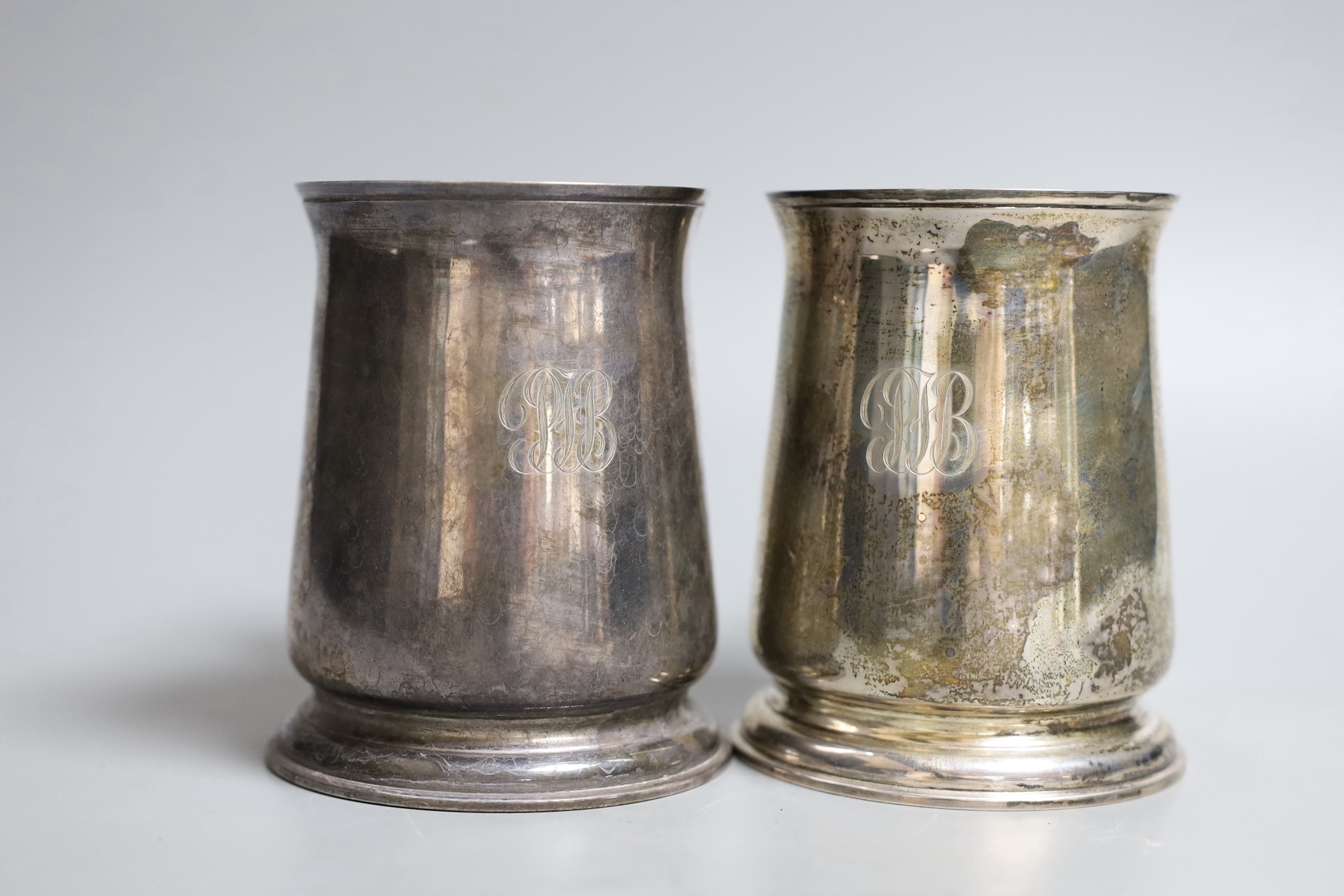 A pair 1970's silver mugs with S-scroll handles, by Asprey & Co Ltd, London, 1973, height 10.8cm, 18.5oz, both with engraved monograms